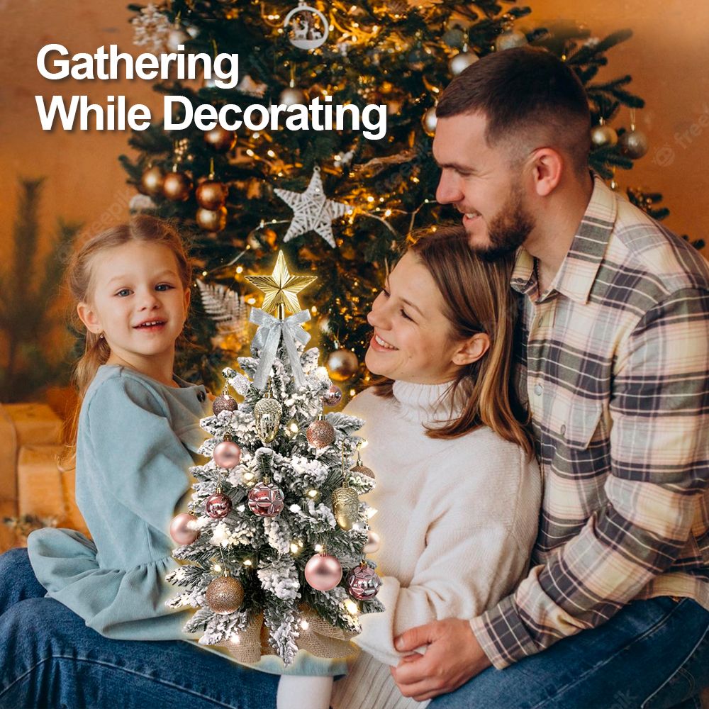 22 inch artificial Christmas tree silver decorated with ornaments beside a family gathering while decorating