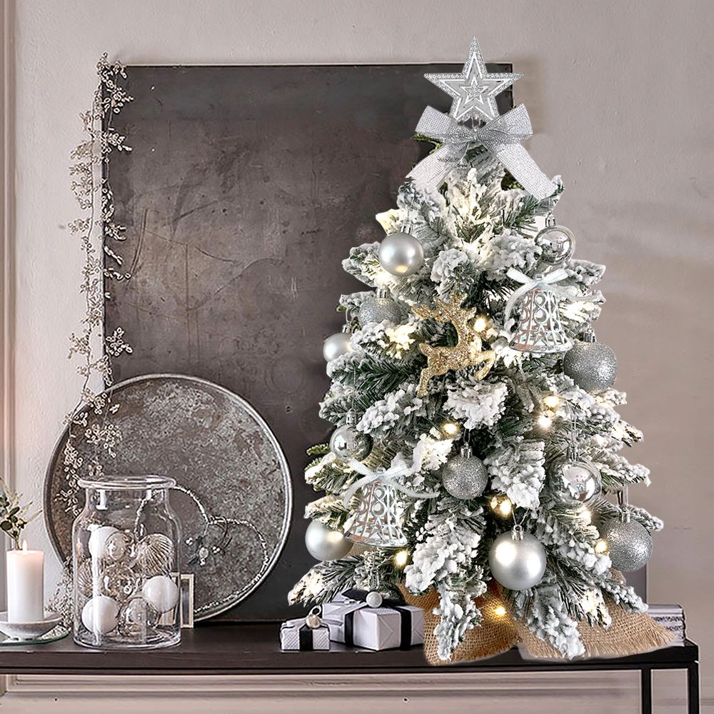 22 inch artificial Christmas tree silver with frosted branches and silver ornaments on table