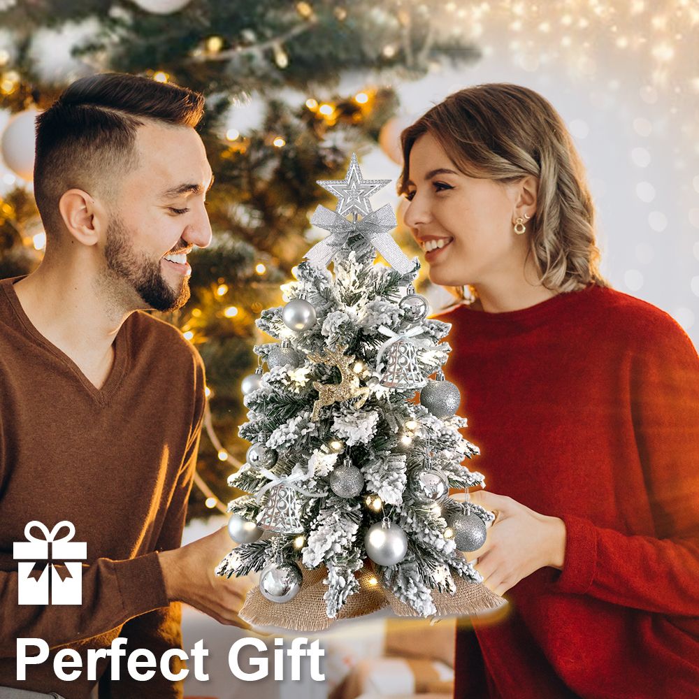 22 inch artificial Christmas tree silver decorated with lights and ornaments held by smiling couple