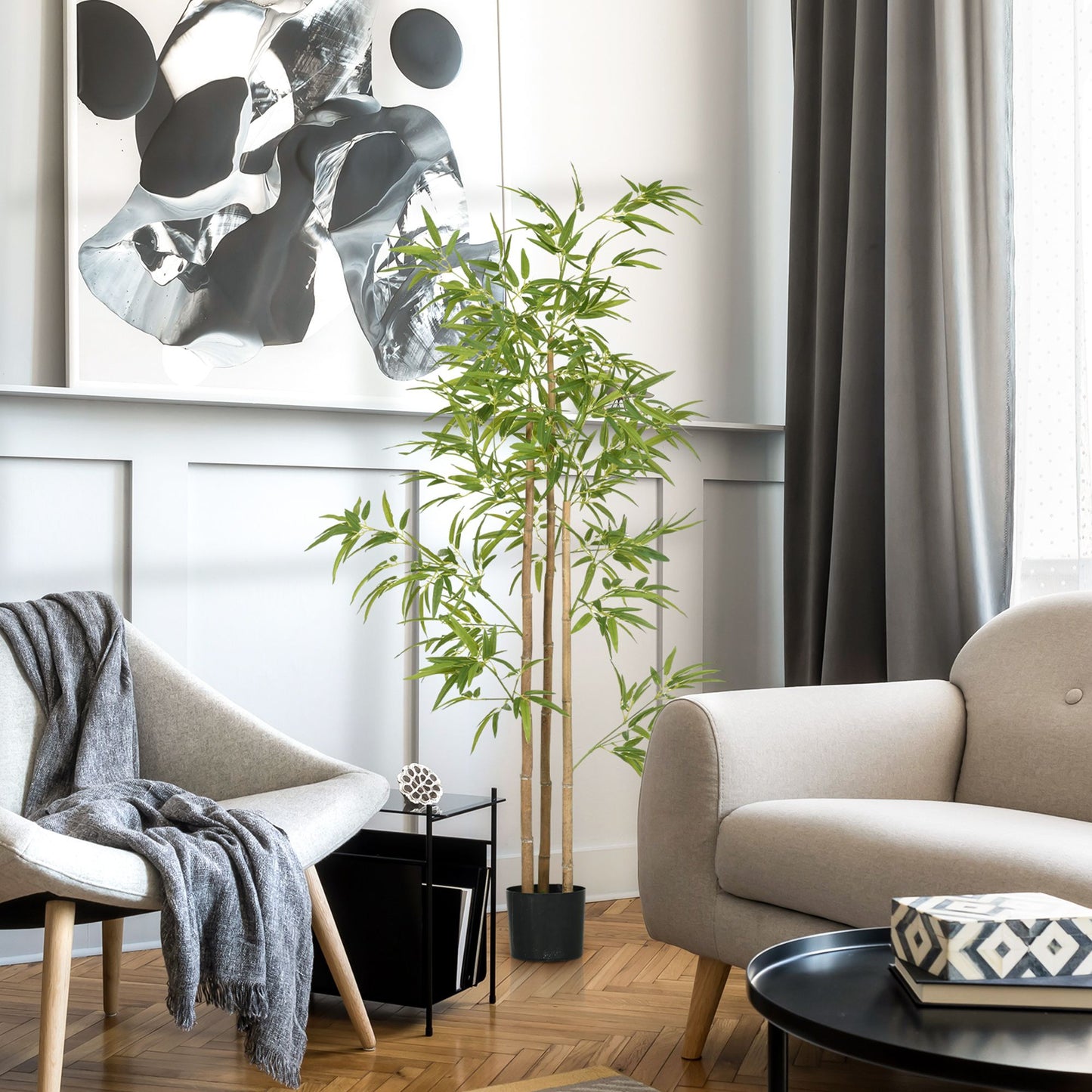 Artificial bamboo tree 6ft in a black pot placed in a modern living room with gray furniture and abstract wall art