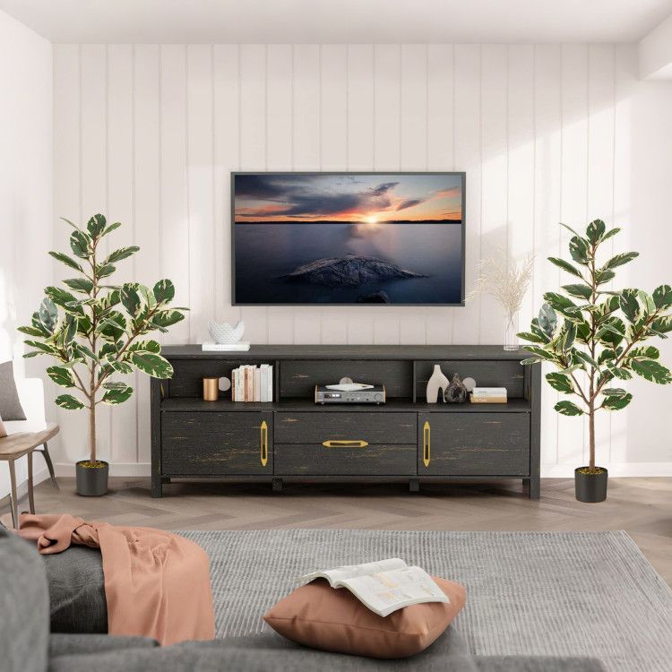 Stylish living room with two artificial bird of paradise plants in modern pots beside a TV stand