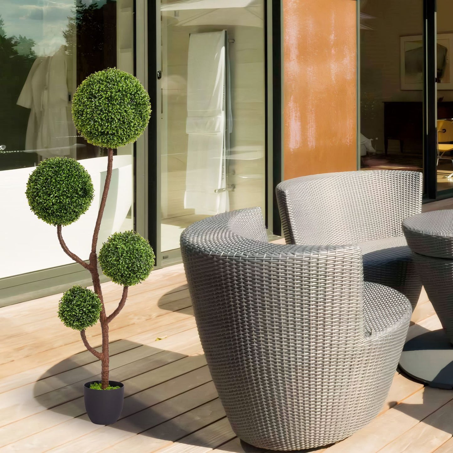 Elegant artificial boxwood topiary in a sleek pot, enhancing outdoor seating area with greenery