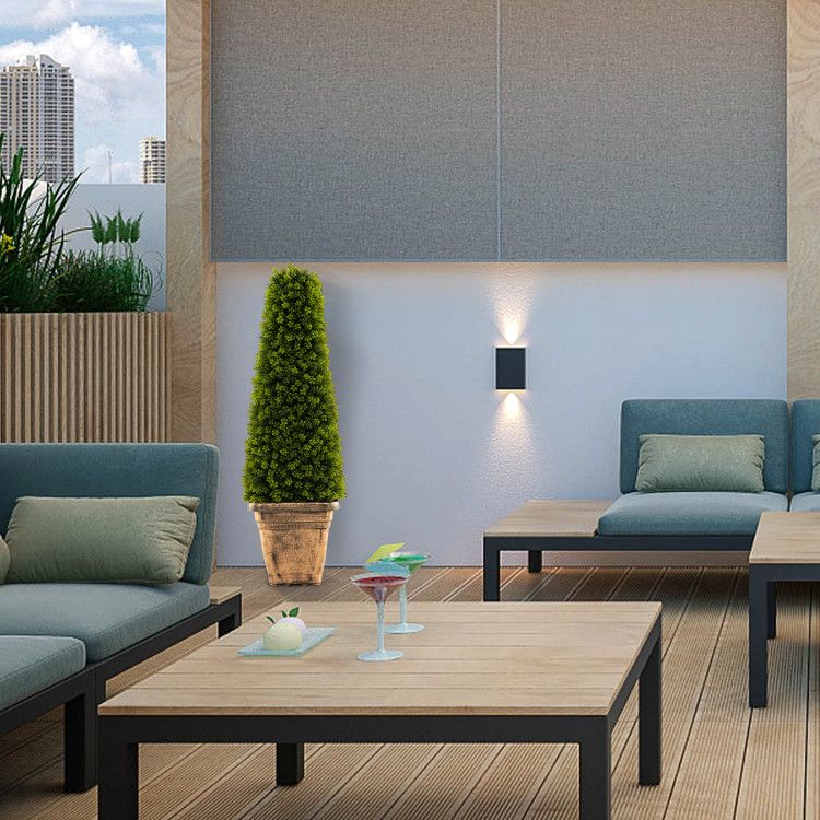 Artificial boxwood topiary tree in a modern indoor setting with stylish furniture and decor