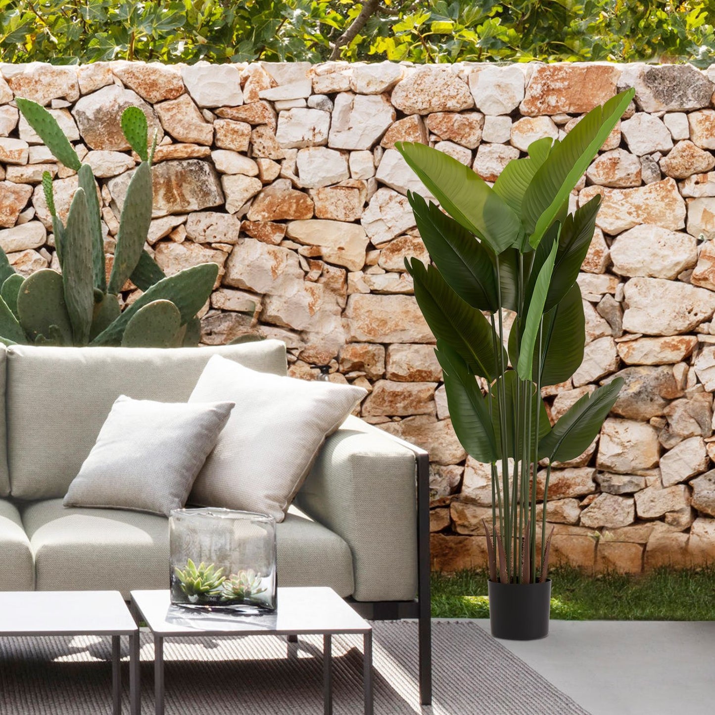 Stylish artificial green plant set in modern living space with stone wall backdrop