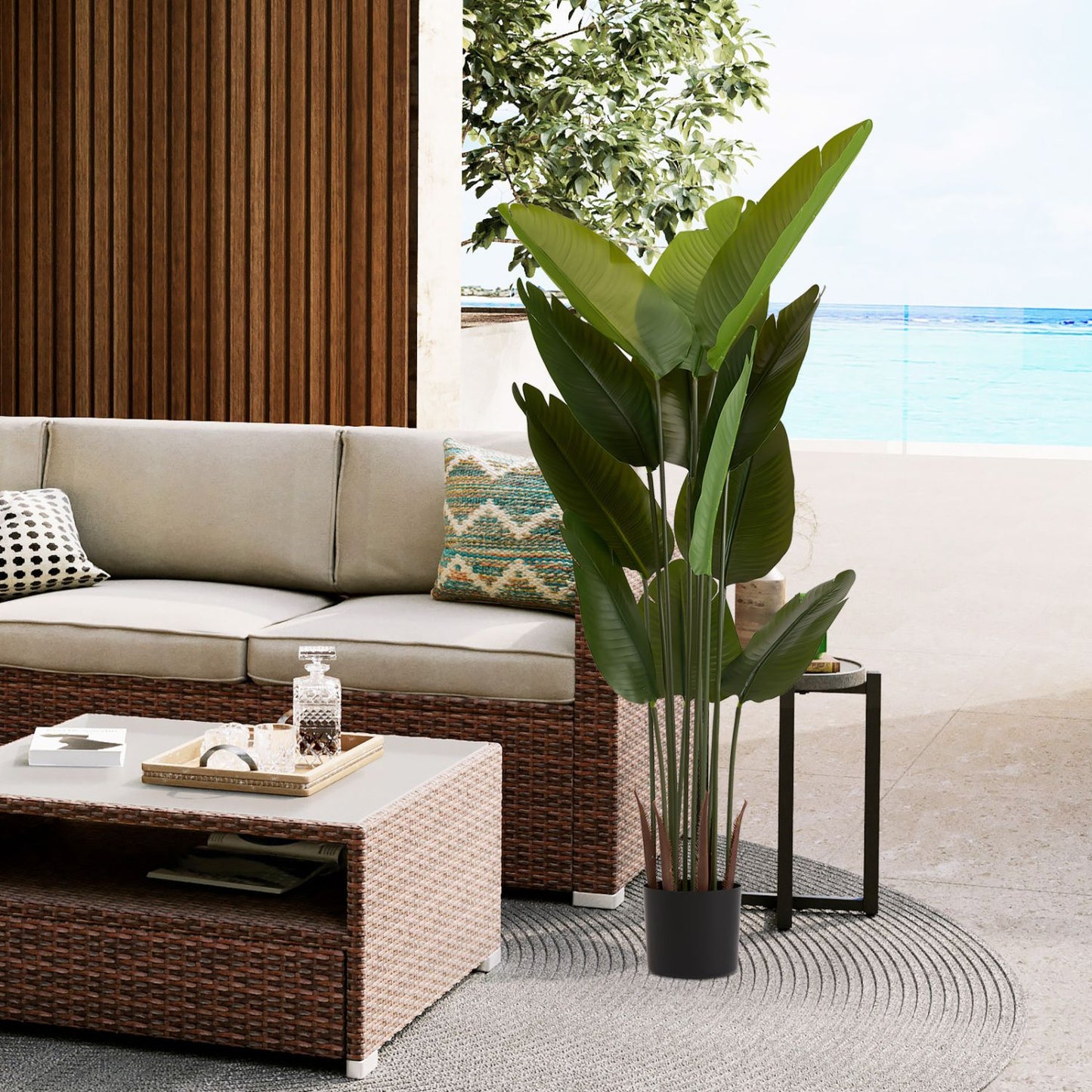 Artificial green plant set displayed in a stylish living area with modern furniture and beach view