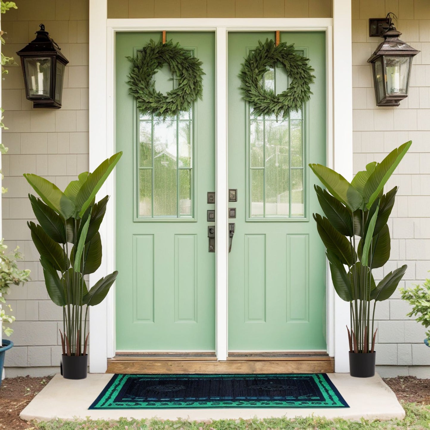 Faux green plant set in stylish black pots flanking a mint green front door for a welcoming entrance