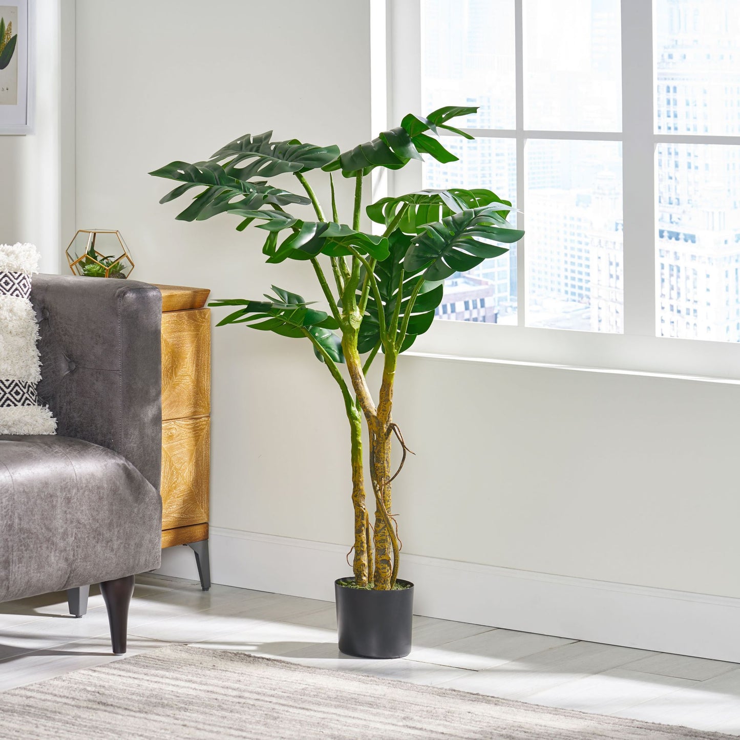 Decorative artificial monstera tree 47 inch in a modern living room setting with plush sofa