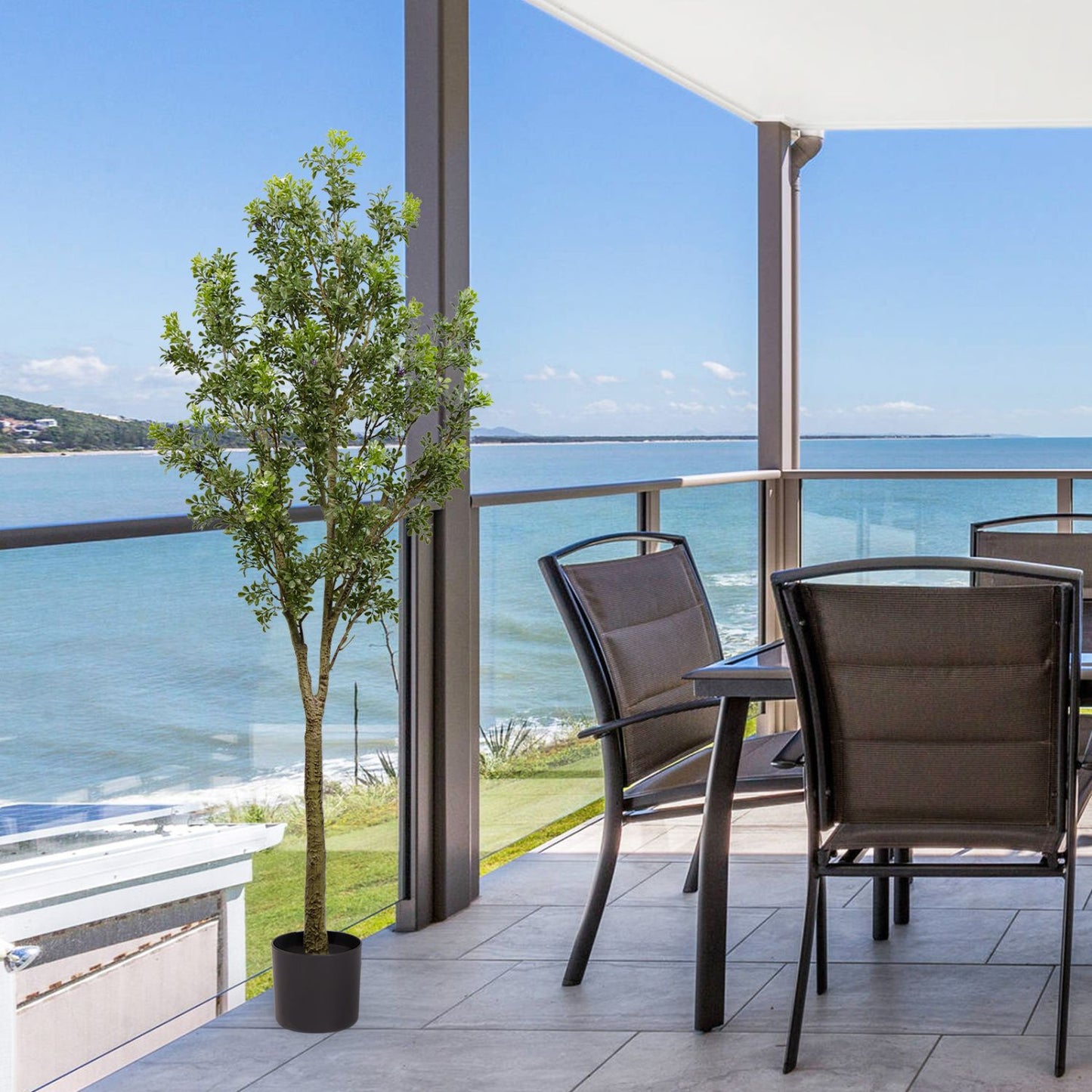 Artificial outdoor garden branches in a potted tree adding greenery to a modern balcony with ocean view