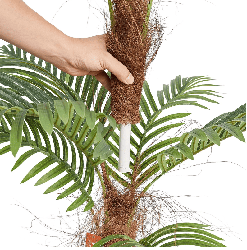 Close-up of a hand assembling a 4 foot artificial palm tree with realistic leaves