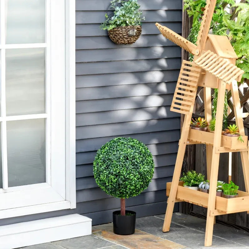 23.5 inch artificial topiary tree in a black pot placed on a patio alongside a wooden plant stand
