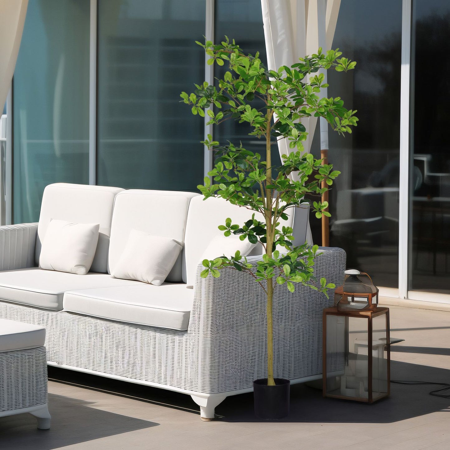Stylish artificial tung tree plant in a modern patio setting next to a white sofa