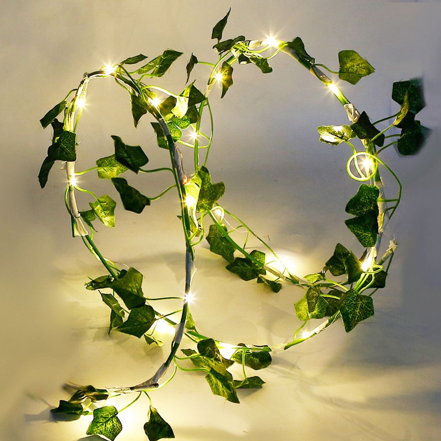 Artificial ivy string lights with green leaves and warm white glowing LED bulbs by FauxMart.com