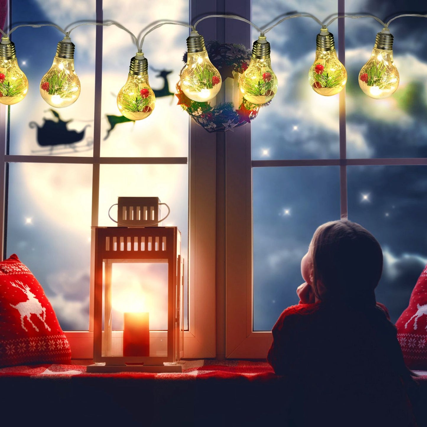 Battery powered Christmas string lights with decorative bulbs hanging above a cozy window scene