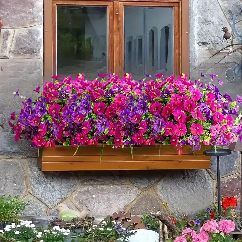 Window box with bright artificial flowers for home in vibrant pink and purple colors