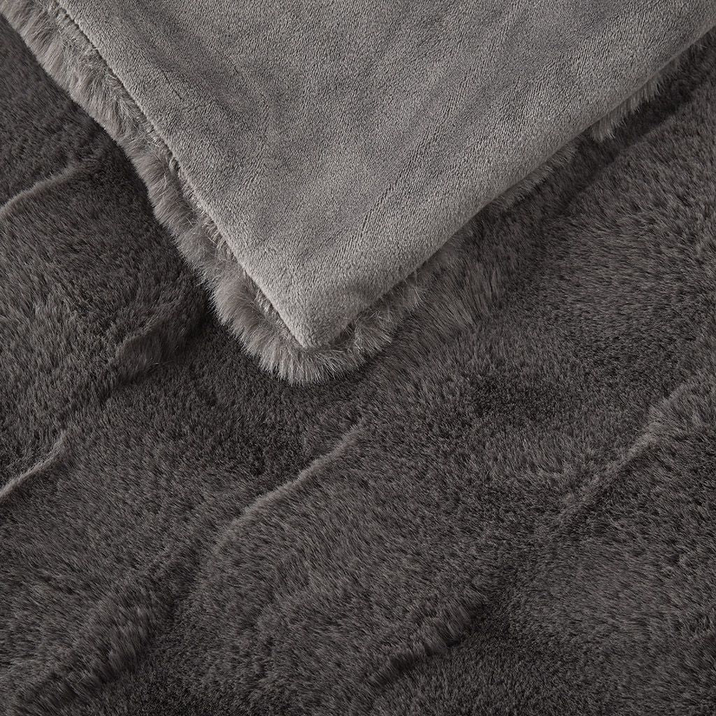 Close-up of a soft gray faux fur throw blanket showing its plush texture and smooth backing