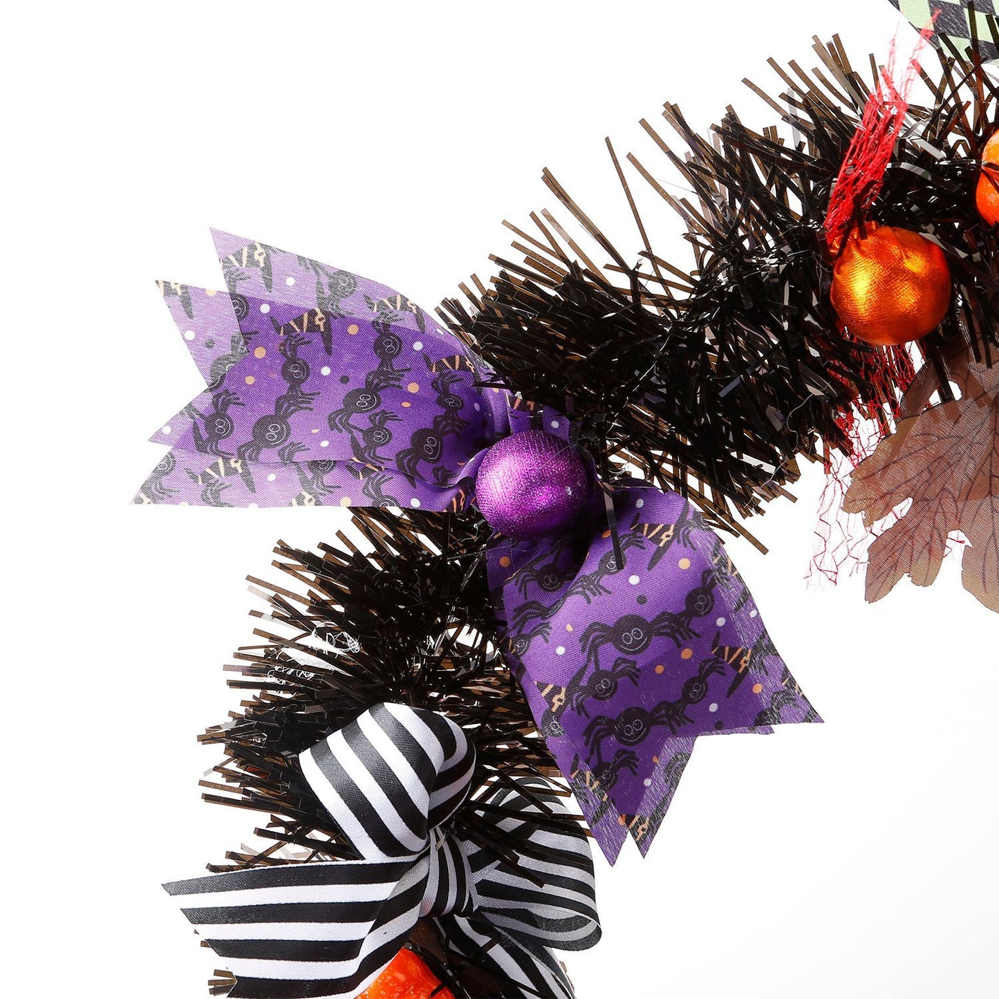 Halloween witch wreath with black tinsel, purple spider patterned bow, striped black and white bow, and orange ornaments