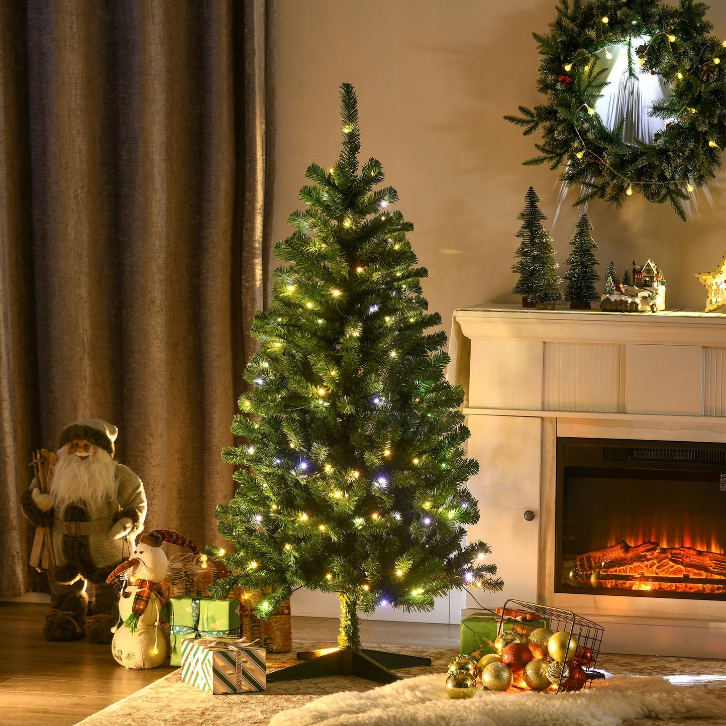Holiday decor LED Christmas tree with warm white lights next to fireplace and wrapped gifts