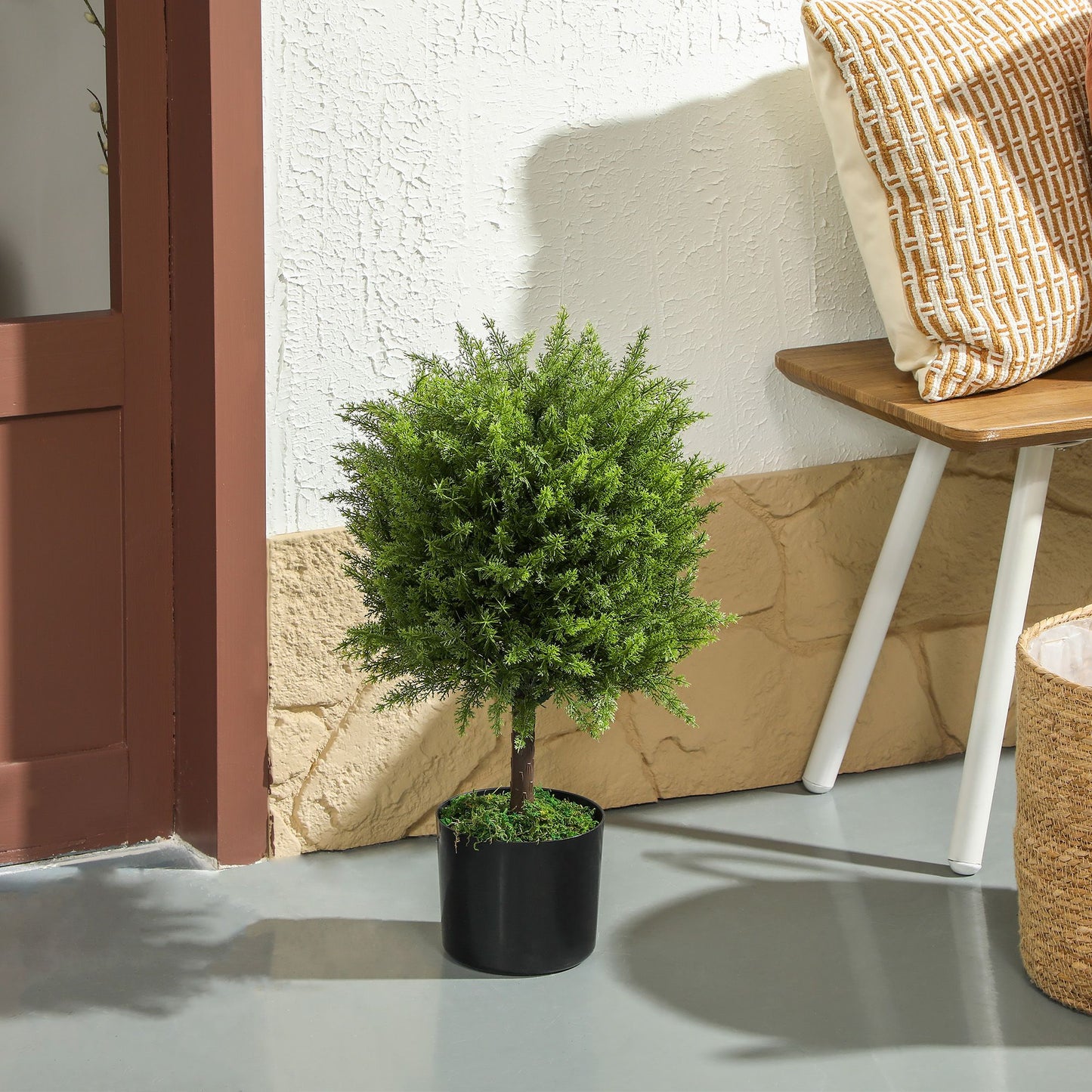 Small green tree in black pot as indoor outdoor fake plants by FauxMart.com near a chair with cushion