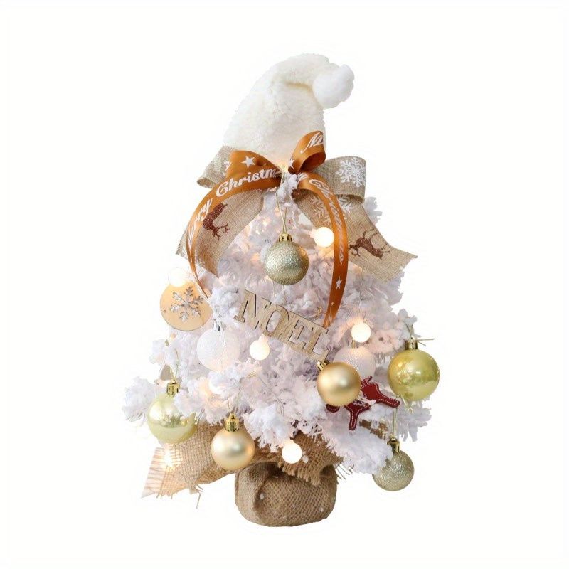 Decorative mini table top Christmas tree in white with ornaments, lights, and a festive hat