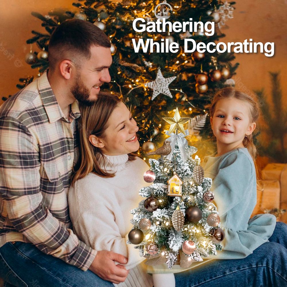 Mini tabletop Christmas tree with lights decorated with gold and silver ornaments displayed with happy family gathering