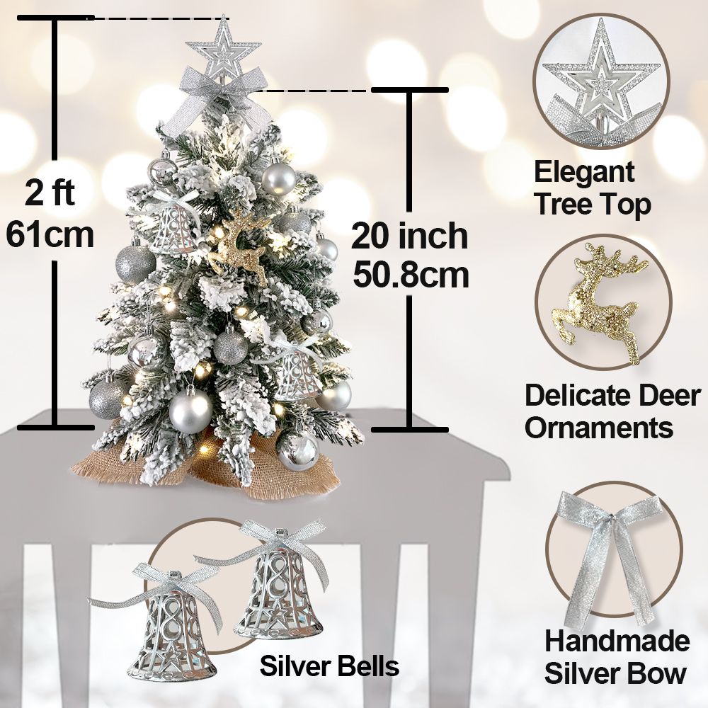 Mini tabletop Christmas tree with lights featuring silver bells deer ornaments and an elegant tree top
