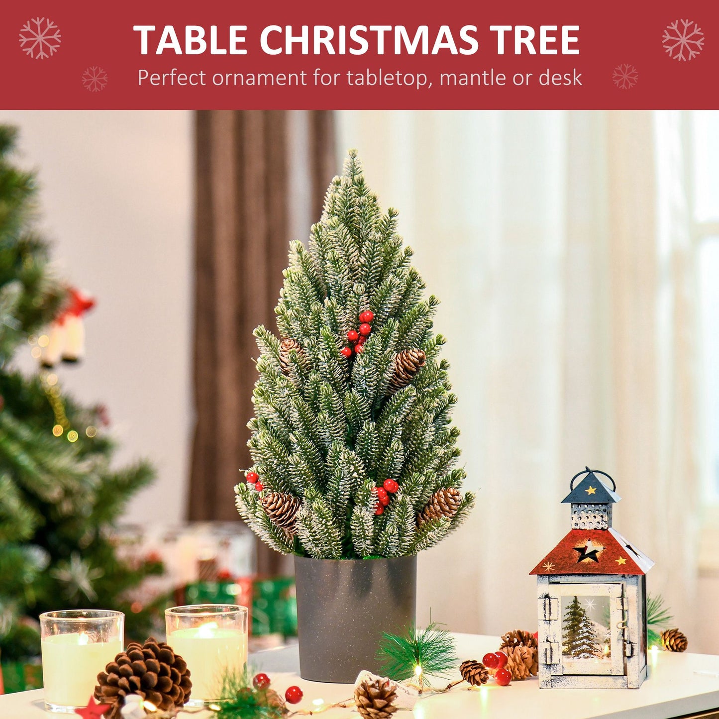 Miniature snow flocked Christmas tree in a black pot, decorated with pinecones and red berries