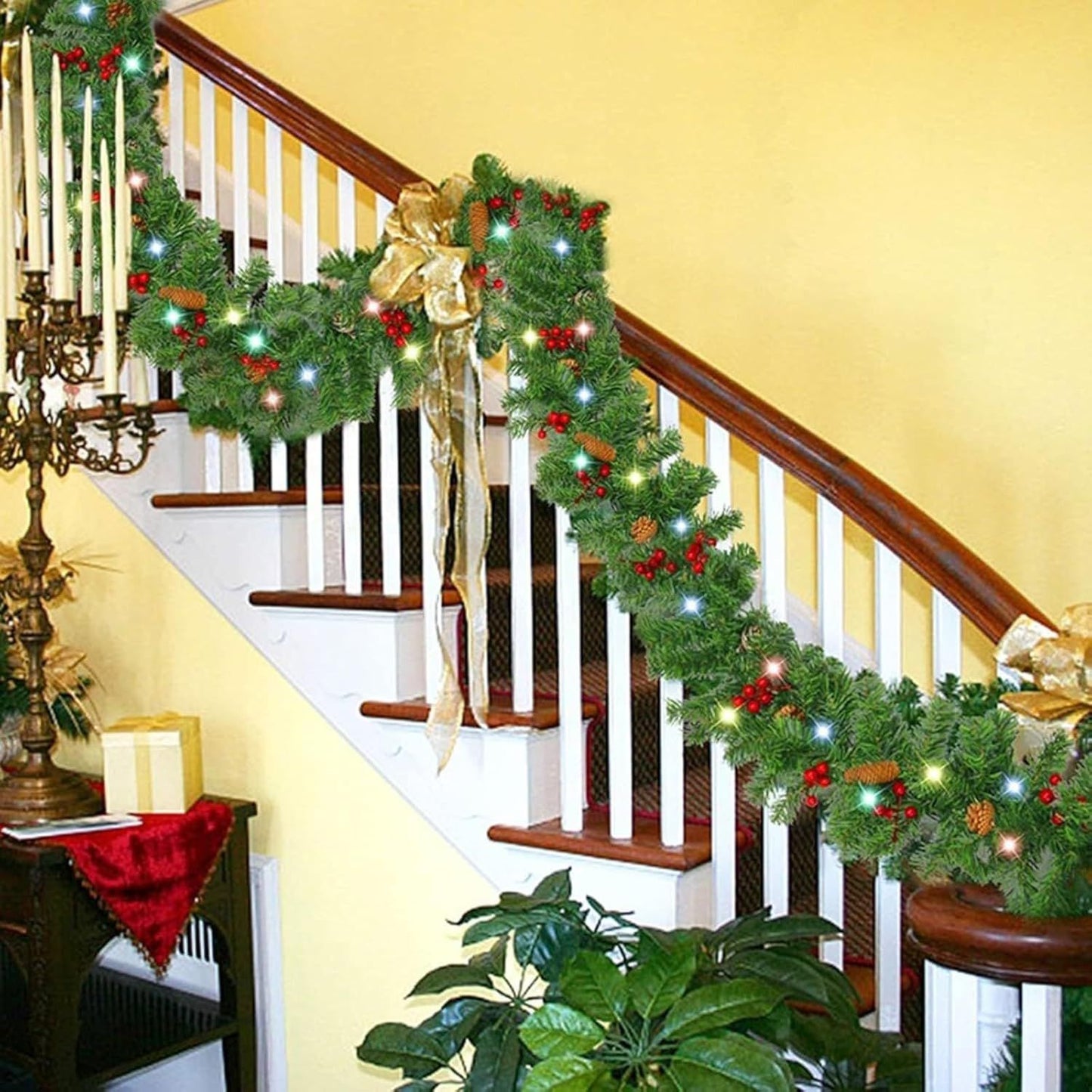Prelit artificial Christmas garland decorated with red berries and bows on a staircase railing