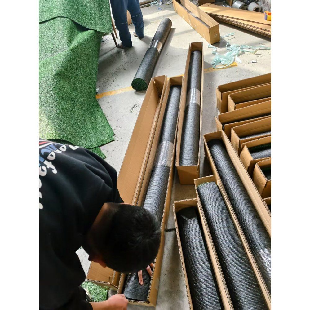 Workers unpacking premium artificial turf mat rolls at FauxMart.com warehouse
