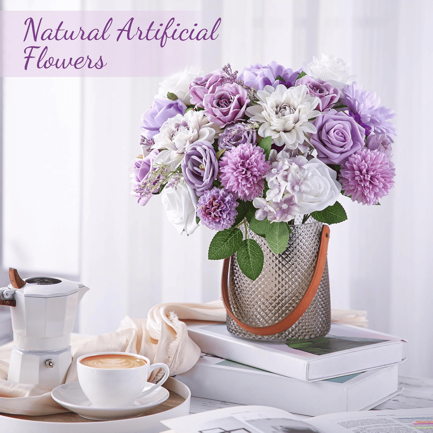 Purple artificial flower arrangement in textured vase with green leaves on a stack of books beside a coffee cup and white coffee maker
