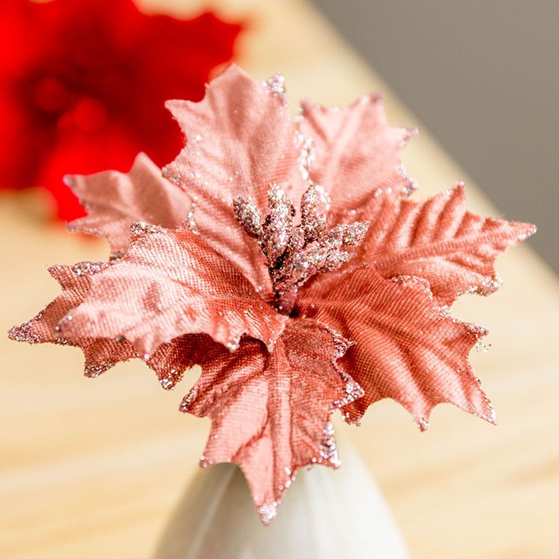 Decorative pink poinsettia flower Christmas ornament with glitter accents on leaves