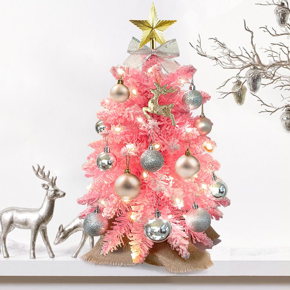 Pink small Xmas tree for office desk decorated with silver and gold ornaments and a star topper