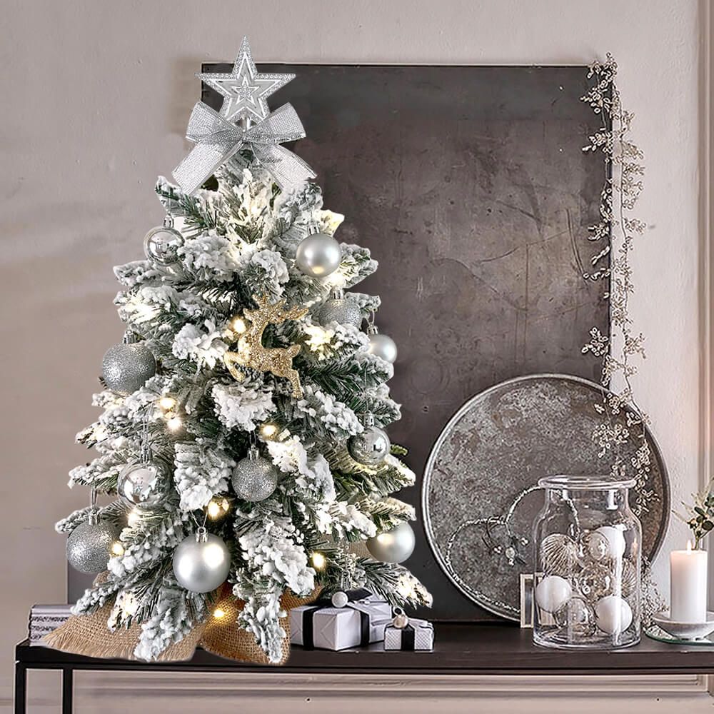 Small Xmas tree for office desk with snow-frosted branches silver ornaments and warm white lights