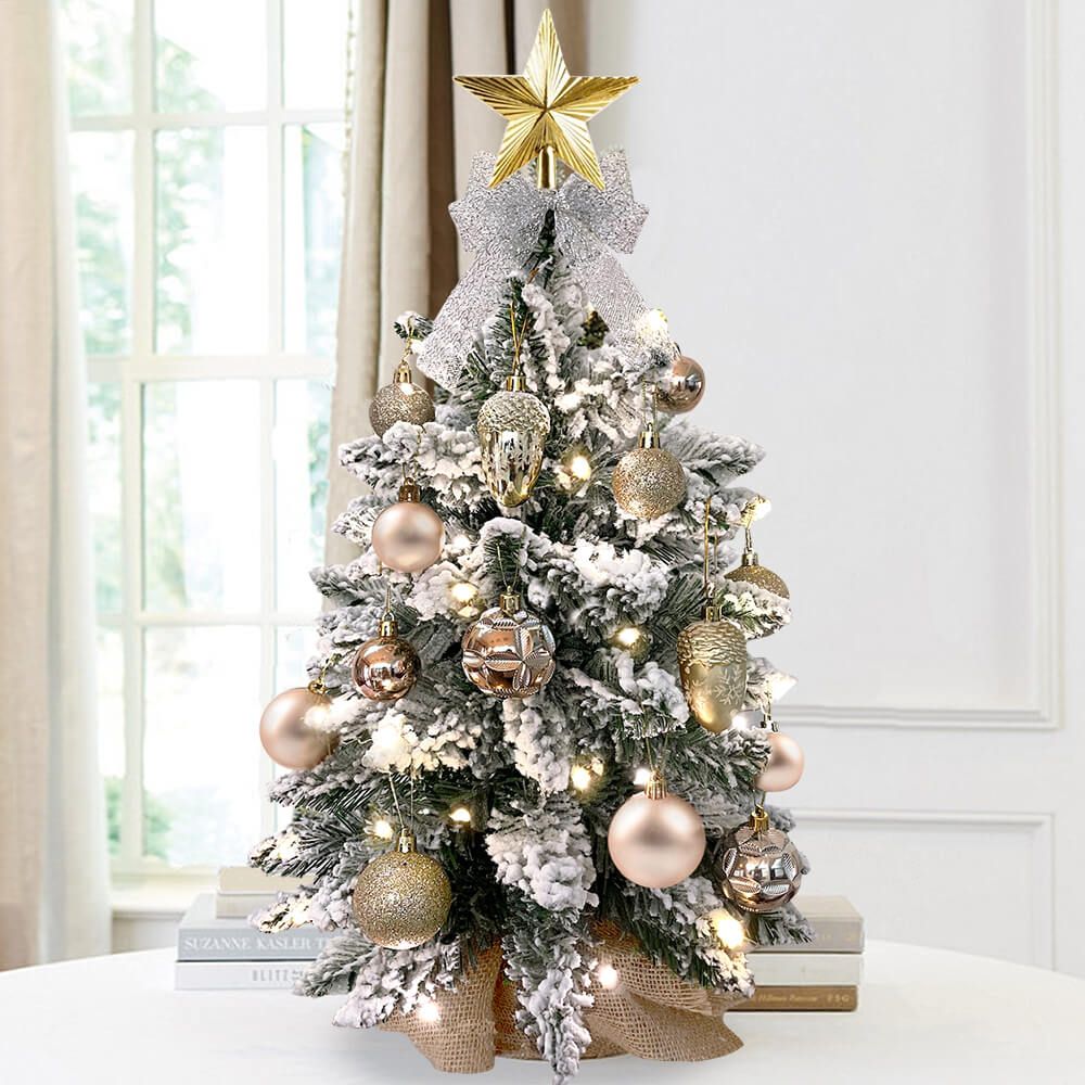 Small Xmas tree for office desk with snow-covered branches and gold ornaments topped with a gold star