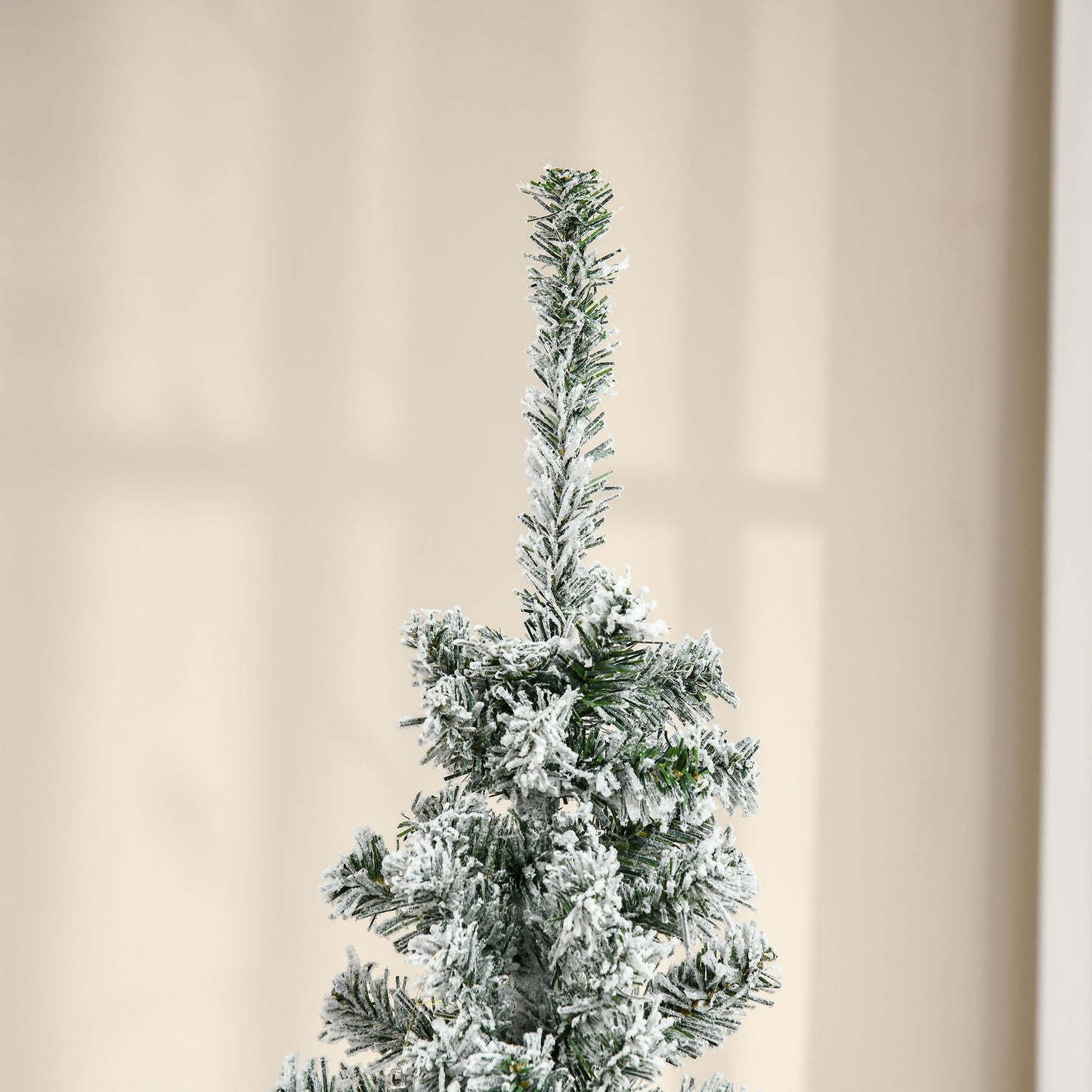 6 foot snow flocked Christmas tree with lush green branches covered in white snow for holiday decor
