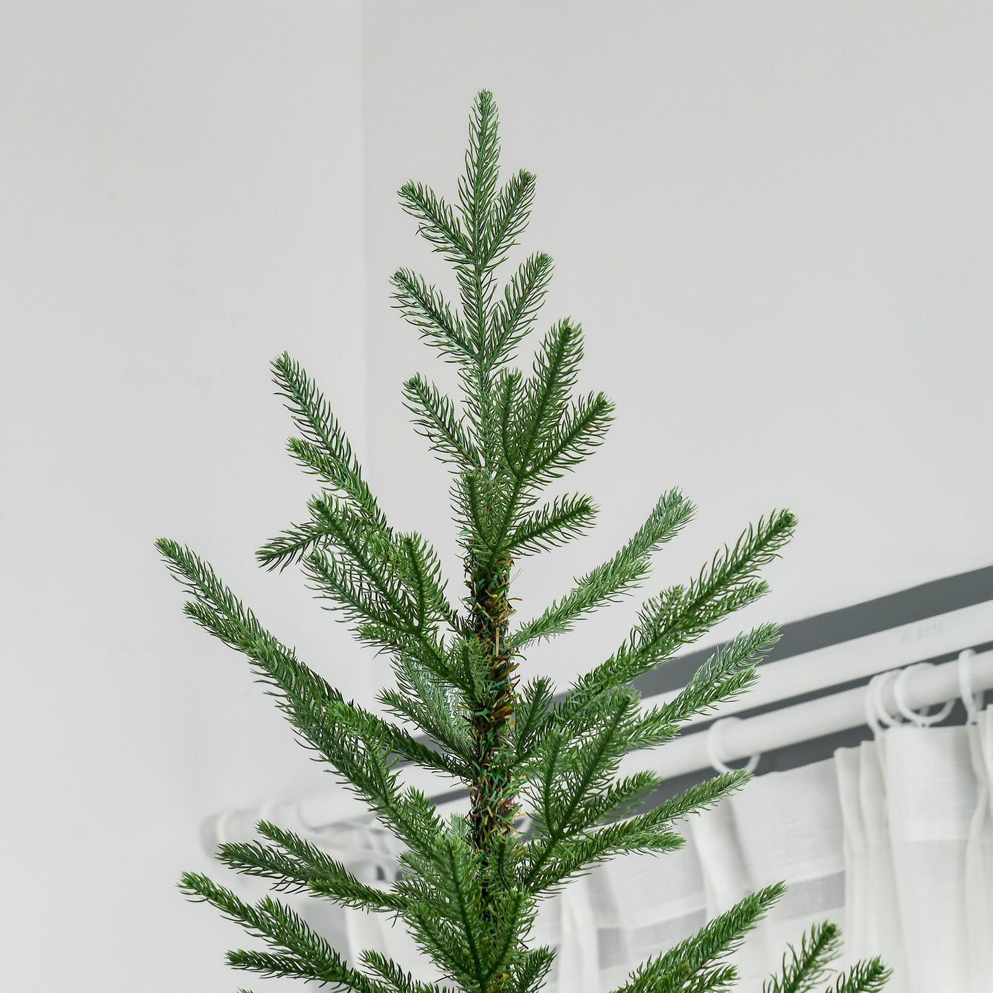 Top section of a 9 ft artificial Christmas tree with realistic green branches indoors