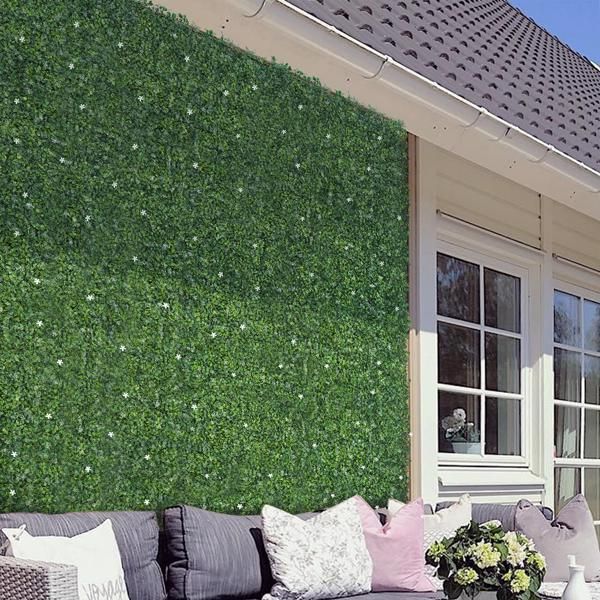 Outdoor wall covered with artificial boxwood hedge panels from FauxMart.com with patio seating area
