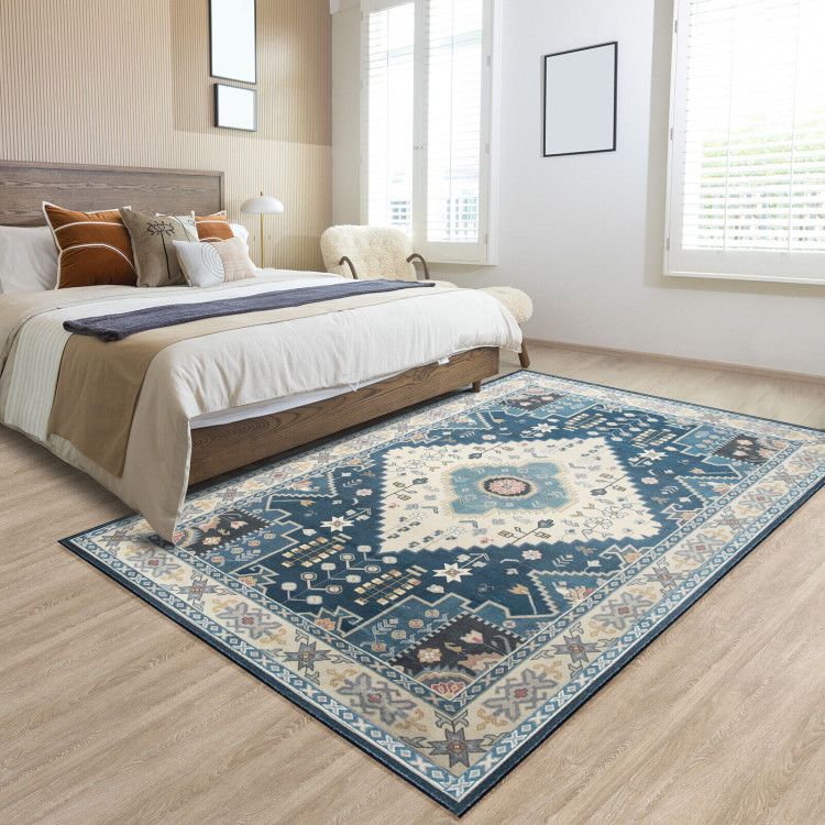 Blue and cream patterned faux wool area rugs under bed in modern bedroom with natural light
