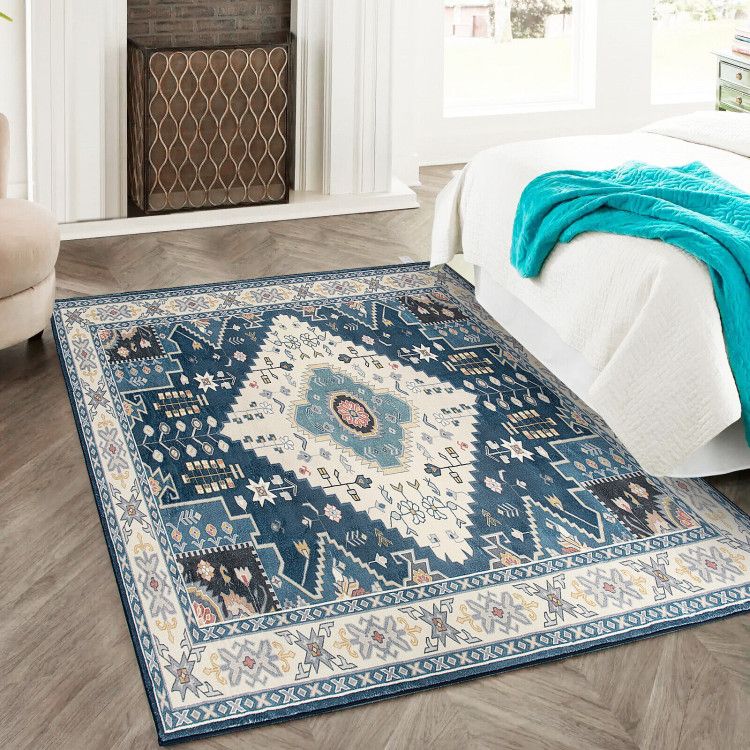 Blue and white patterned faux wool area rugs in bedroom with hardwood floor and white bedding