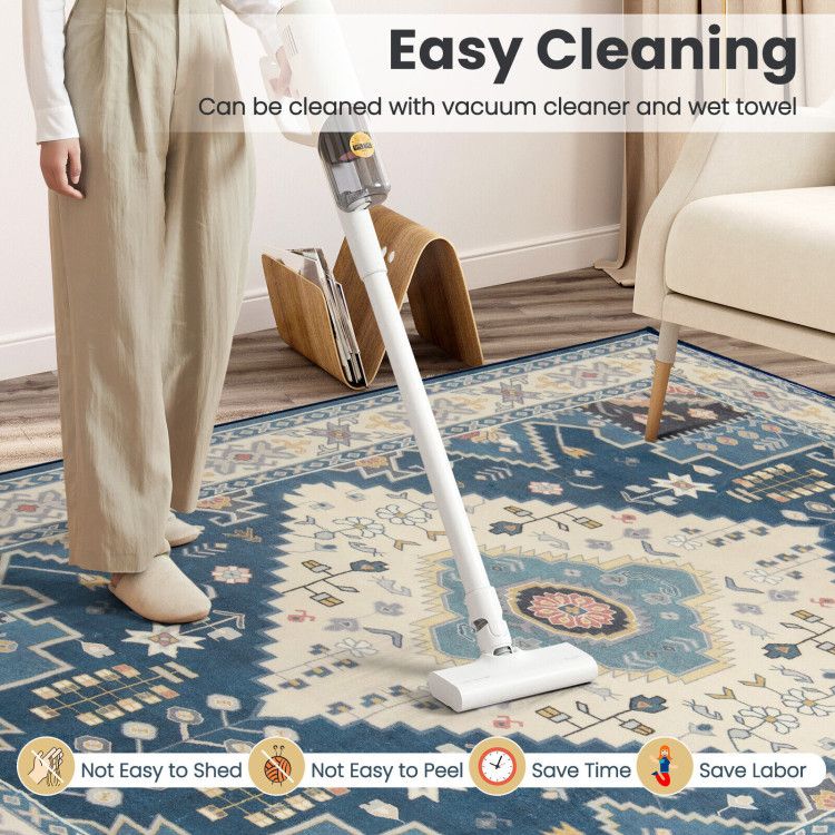 Person vacuuming blue patterned faux wool area rugs with easy cleaning features from FauxMart.com