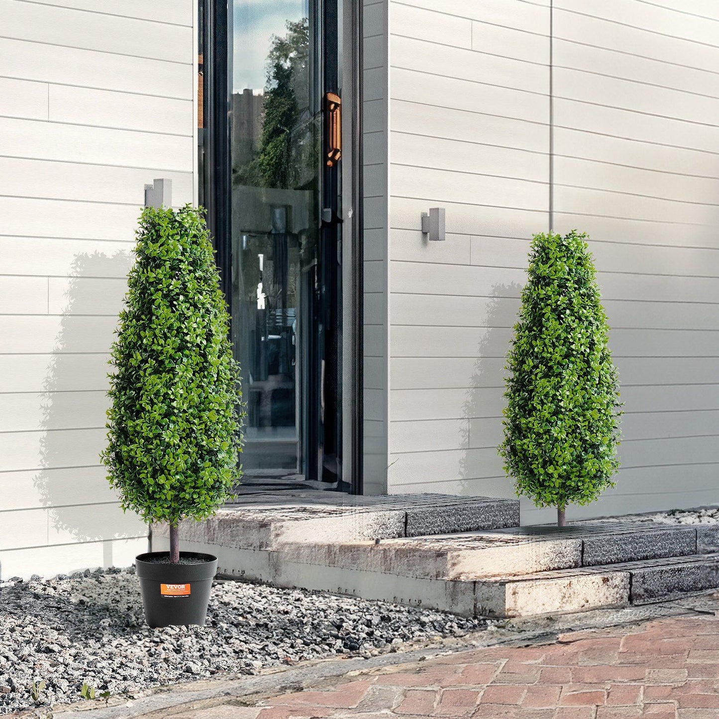 3 foot fake topiary pair in black pots displayed outside a modern home entryway