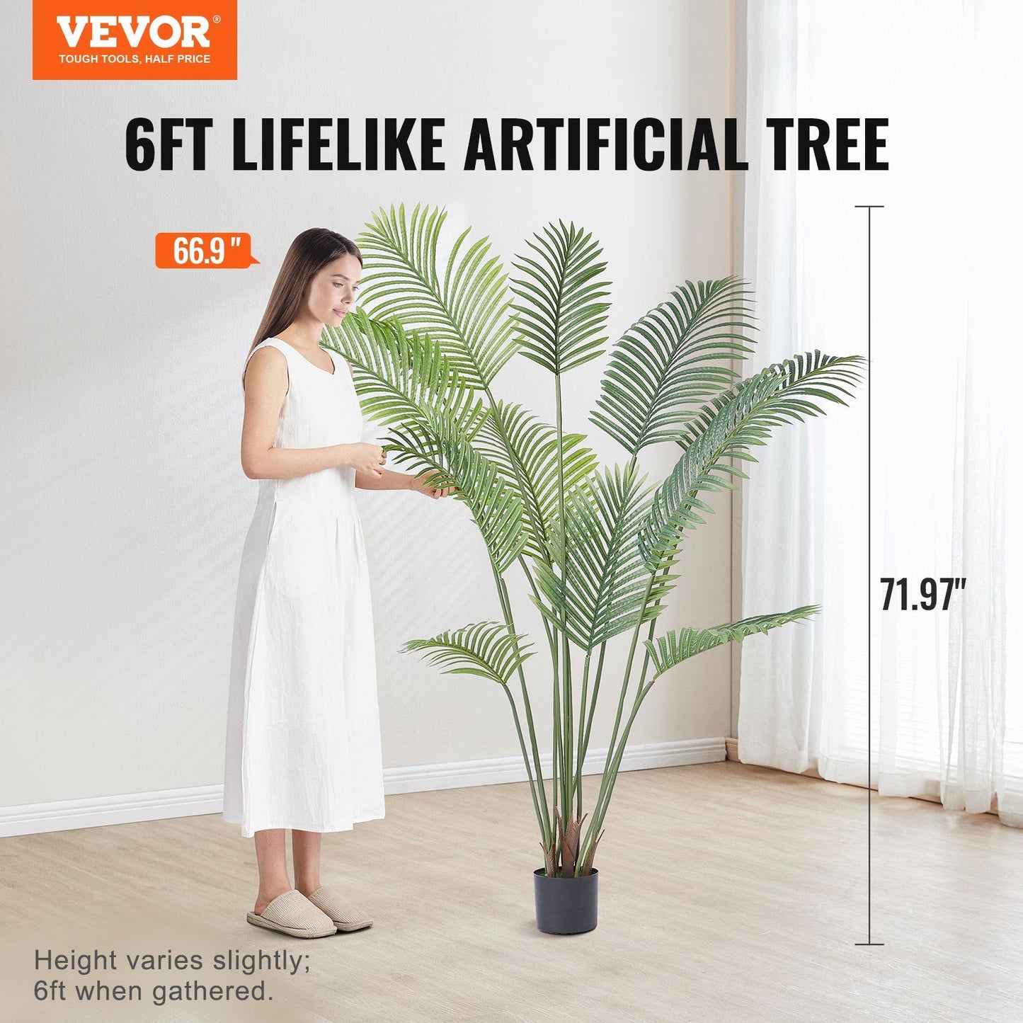 6ft artificial palm tree in a black pot with a woman in white dress for scale in bright room