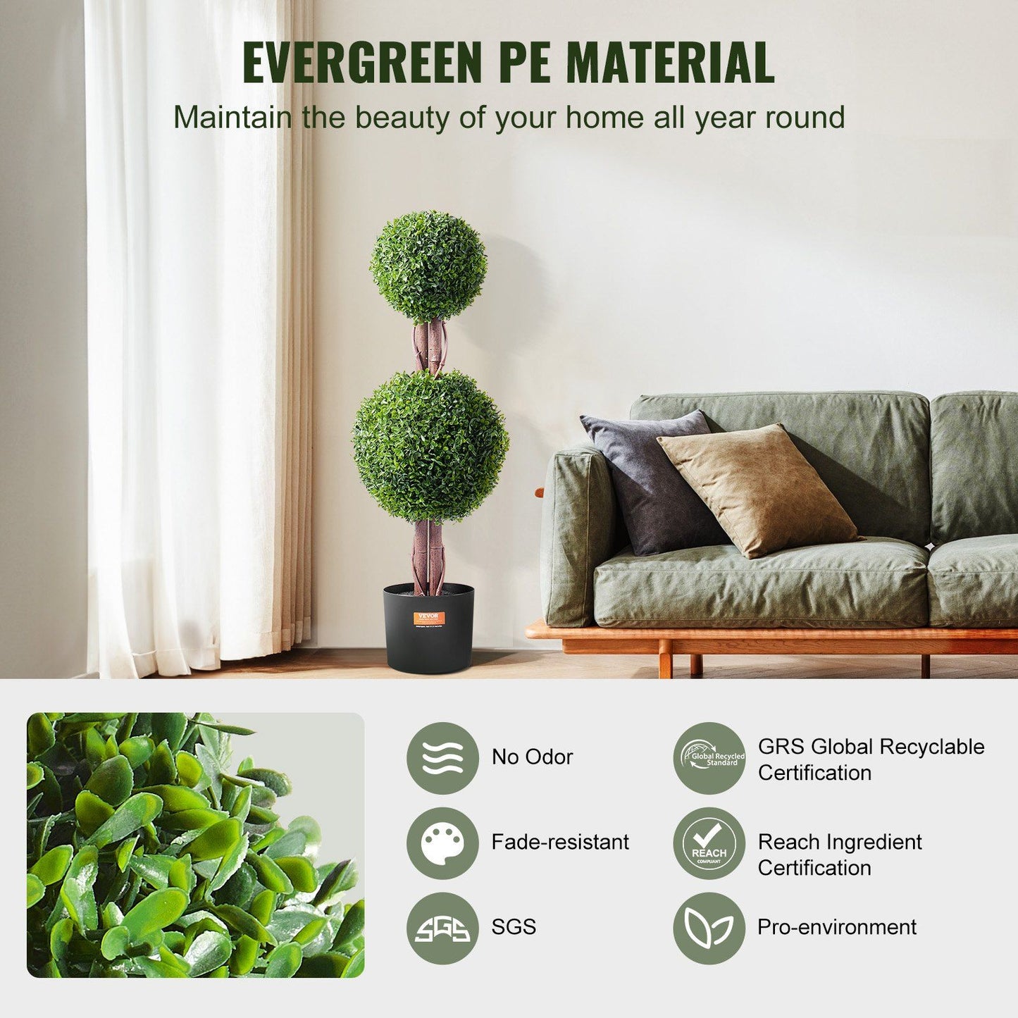 Artificial boxwood topiary tree with two green foliage spheres in black pot next to sofa indoors