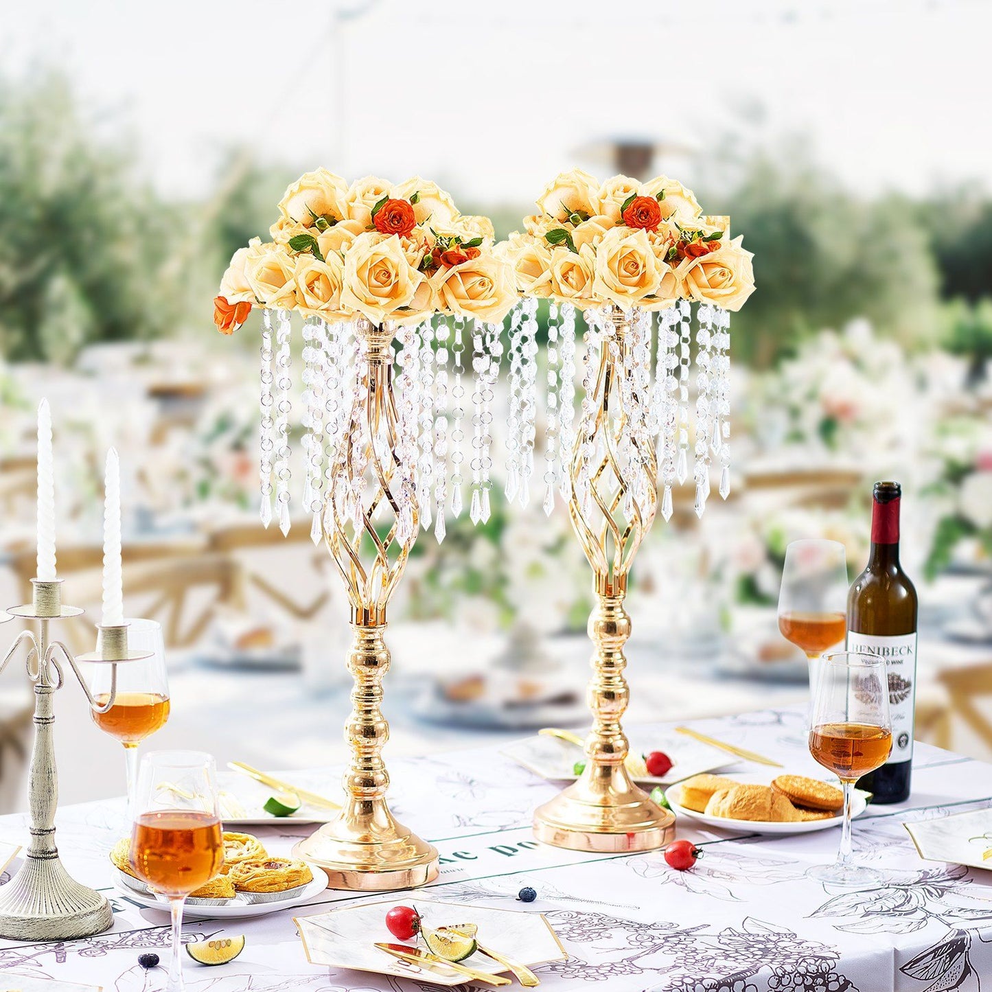 Elegant tall crystal wedding flower stand with yellow roses and hanging crystal beads on a decorated table