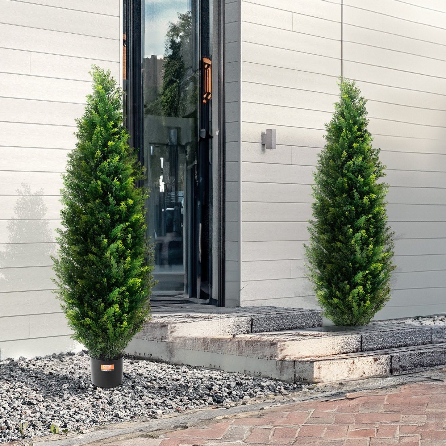 UV resistant faux plants outdoor tall green pine trees in black pots placed near modern house entrance