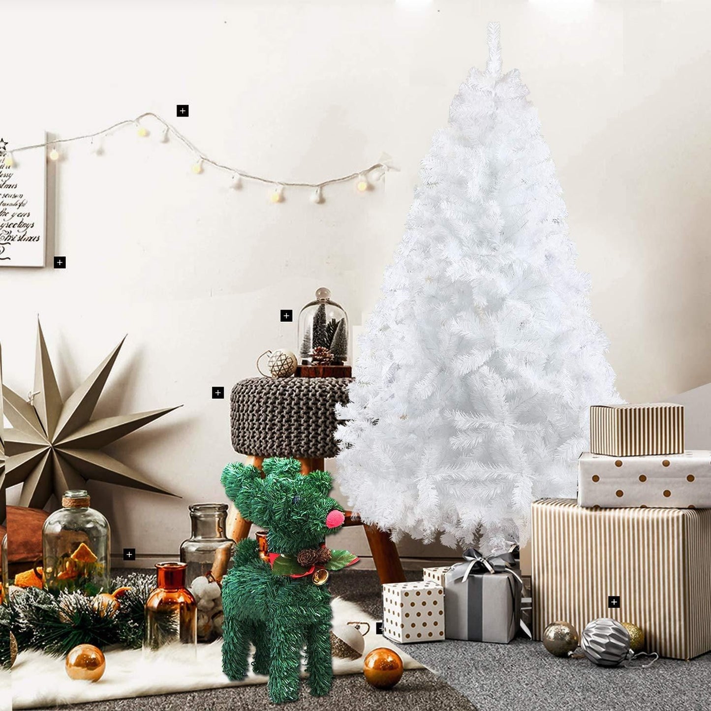 White artificial Christmas tree decorated with wrapped gifts and holiday decor in cozy living room