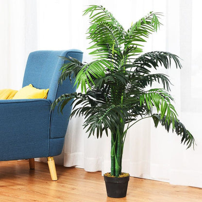 Artificial areca palm tree in a black pot next to a blue armchair for home decor