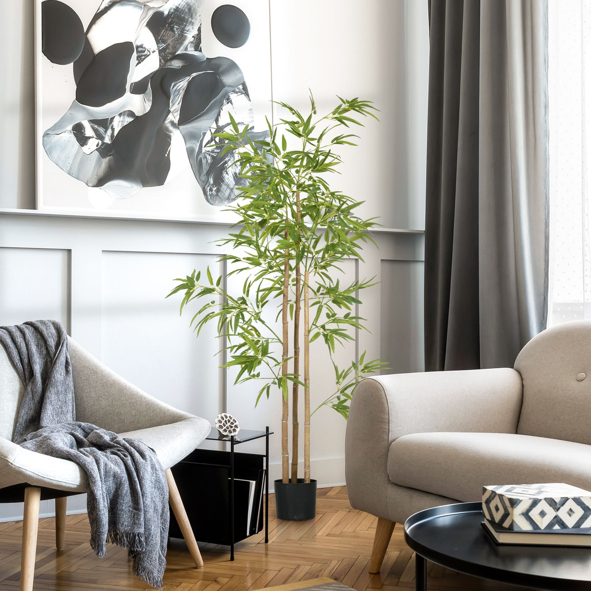 Artificial bamboo tree 6ft in a black pot placed in a modern living room with gray furniture and abstract wall art
