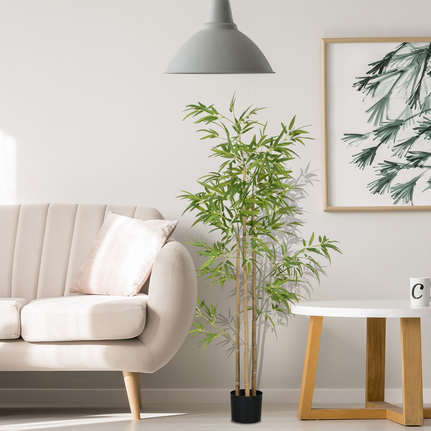 Artificial bamboo tree 6ft in black pot placed in modern living room next to beige sofa and white side table