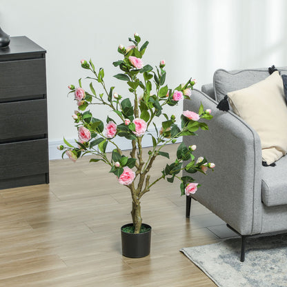 Artificial camellia flowers in pots with pink blooms and green leaves next to gray sofa and black drawer