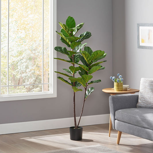 Artificial fiddle leaf fig tree with large green leaves in black pot next to gray sofa in modern living room
